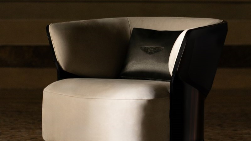 poltrona Embrace da Bentley Home com estrutura curva e design envolvente