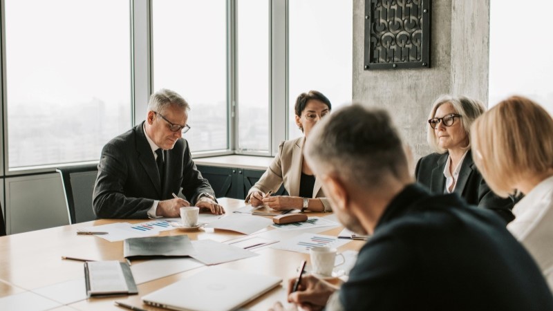 Profissionais discutindo estratégias em reunião corporativa com foco em integração e crescimento