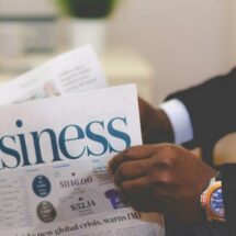 Empresário em escritório moderno olhando pela janela com vista para a cidade em momento de reflexão estratégica sobre venda e valor da empresa