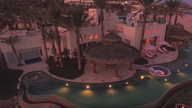 Vista aérea noturna da Ty Warner Mansion iluminada à beira-mar