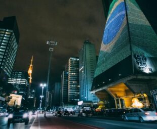 Vista noturna da Avenida Paulista com o edifício da FIESP iluminado, símbolo do lifestyle, da cultura e da vida urbana em São Paulo