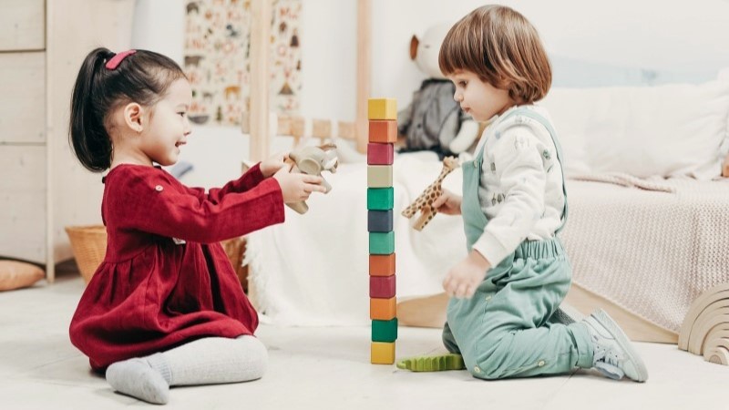 Menino e menina brincando juntos em momento de interação e desenvolvimento infantil