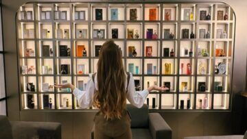 Pessoa observando uma prateleira repleta de perfumes em referência ao burnout olfativo e excesso de estímulos na perfumaria