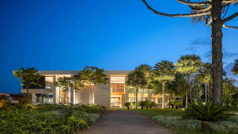 Fachada contemporânea com paisagismo sofisticado e iluminação arquitetônica em Brasília