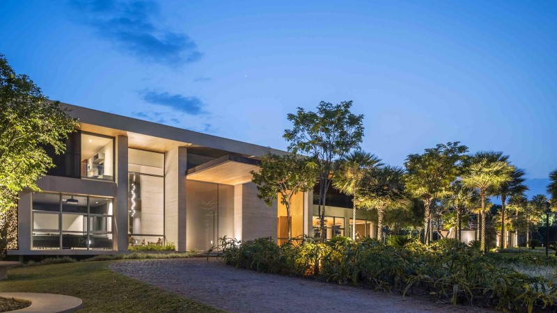 Paisagismo residencial de luxo com iluminação cenográfica ao entardecer em Brasília