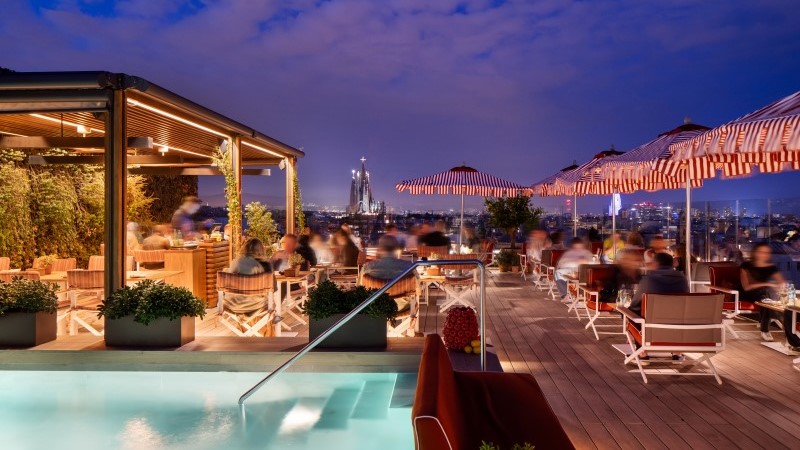 Ambiente elegante do rooftop de luxo La Dolce Vitae no Majestic Hotel & Spa Barcelona ao entardecer