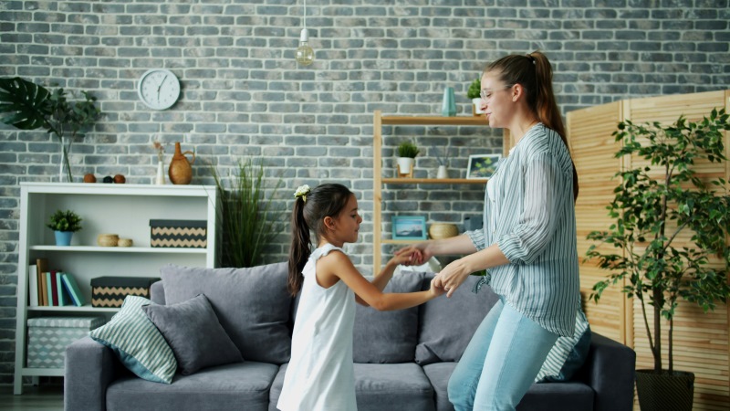 Mãe brincando e dançando com a filha em momento de conexão emocional