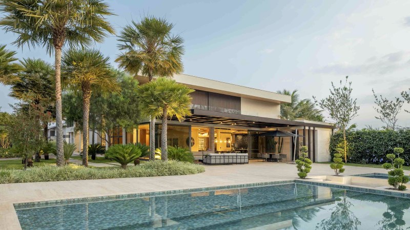 Piscina integrada ao paisagismo em residência de alto padrão com arquitetura contemporânea