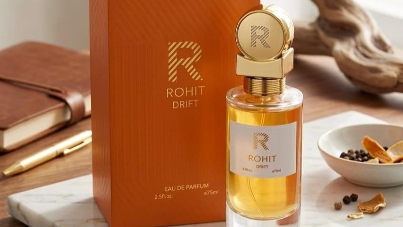 Frasco do perfume Rohit Rouge Drift com design intenso em tons escuros e avermelhados