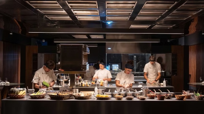 Chefs do restaurante Tuju preparando pratos em uma experiência de alta gastronomia em São Paulo