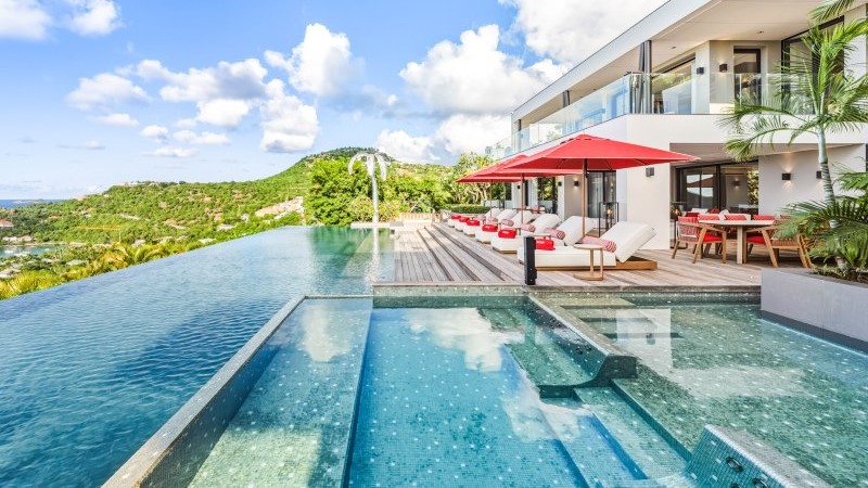 Piscina infinita da Villa NEO em Saint Barth com daybeds e vista para o Caribe