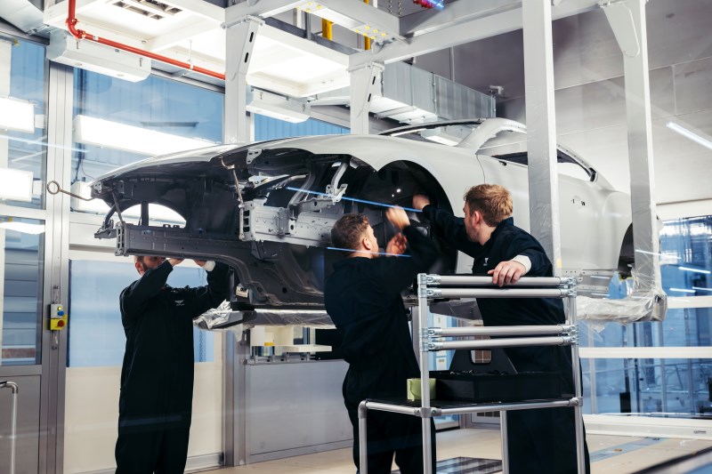 Especialistas da Bentley trabalham manualmente na carroceria durante o processo de personalização de carros de luxo