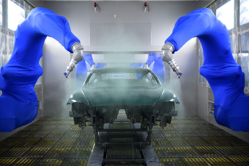 Braços robóticos realizam o processo de pintura automotiva premium na nova fábrica da Bentley