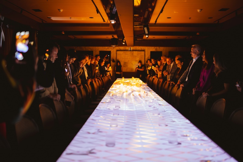 Mesa central da Class TechExperience com efeitos de luz, convidados posicionados para a experiência Royal Salute no Rosewood São Paulo