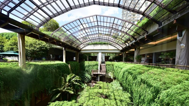 Estrutura arquitetônica com vidro e áreas verdes no empreendimento