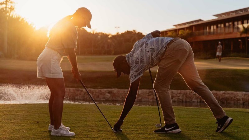 Jogadora de golfe com instrutor no Zendaya Resort