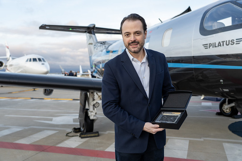 João Mellão, CEO da Amaro Aviation, segurando uma caixa durante evento
