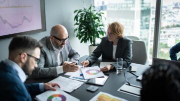 Reunião estratégica com documentos financeiros para preparação de empresa para venda
