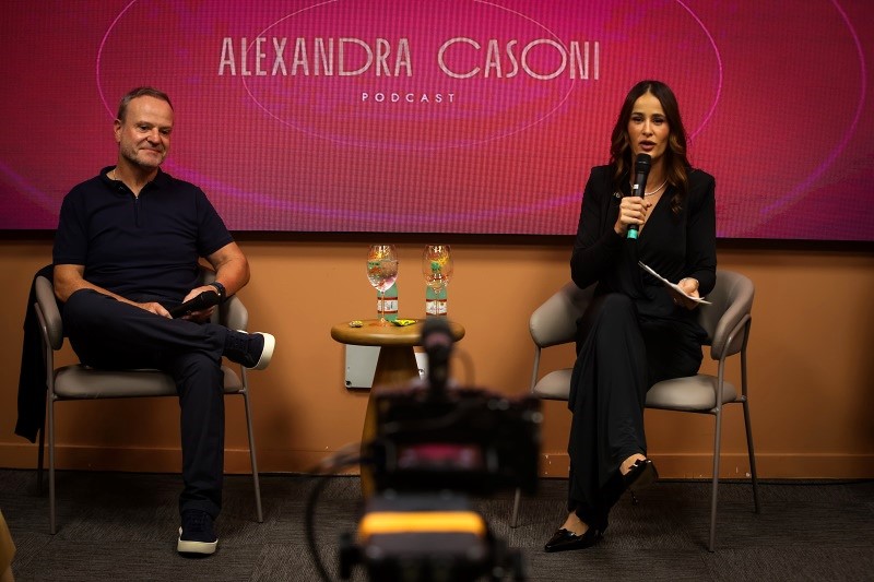 Rubens Barrichello e Alessandra Cassoni sentados na plenária durante o evento