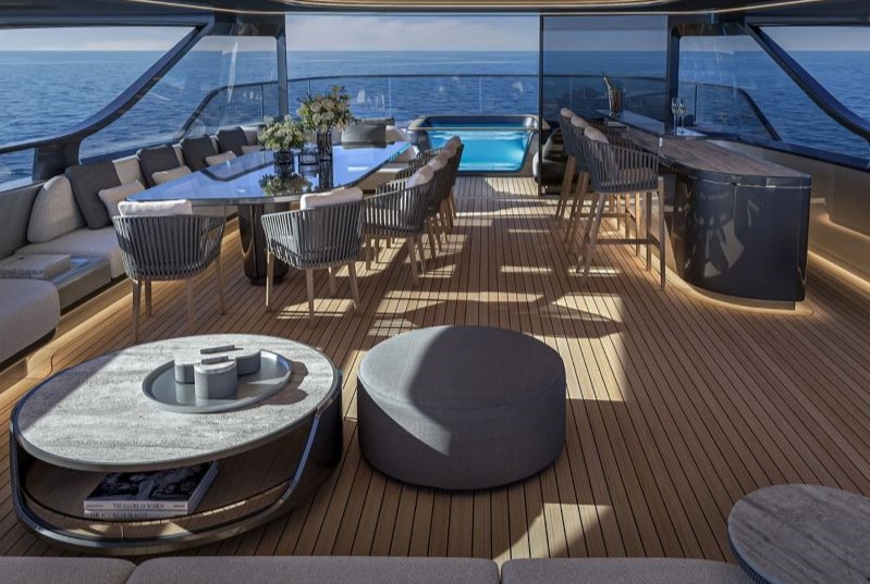Deck do Project53 com mesa, bar e piscina ao fundo