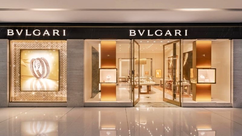 Fachada de boutique Bvlgari com vitrines e interior da loja visível