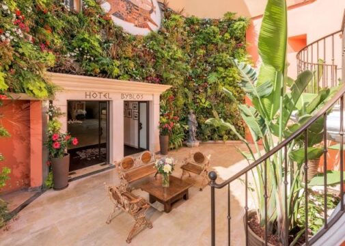 Entrada do Byblos Saint Tropez cercada por vegetação