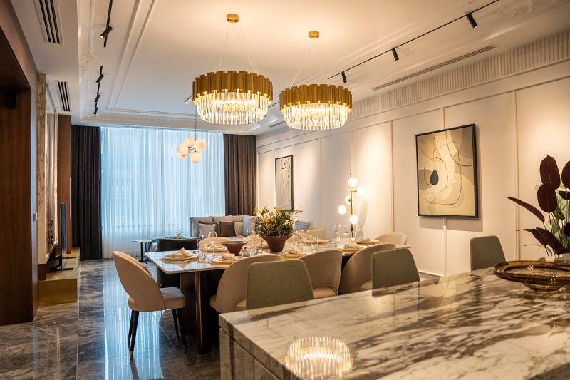 Living room com mesa de jantar ao centro e sofá ao fundo em ambiente sofisticado