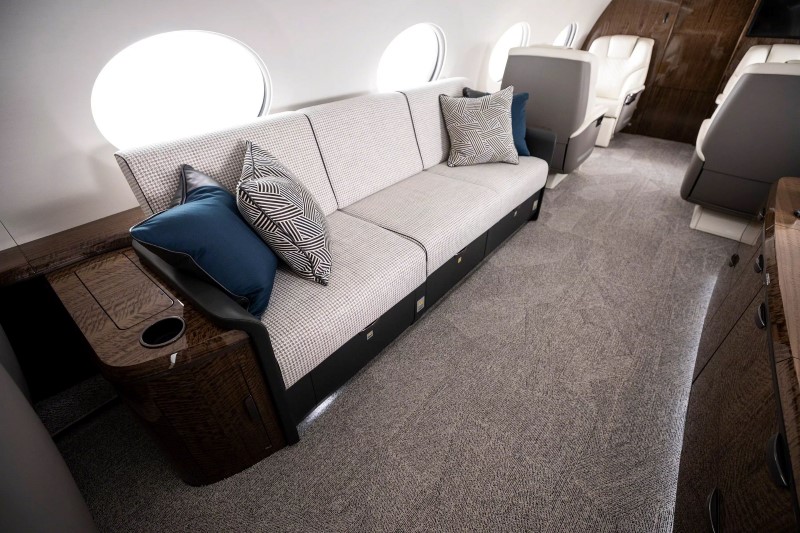 Área de convivência da cabine do Gulfstream G700 com sofá e mesa