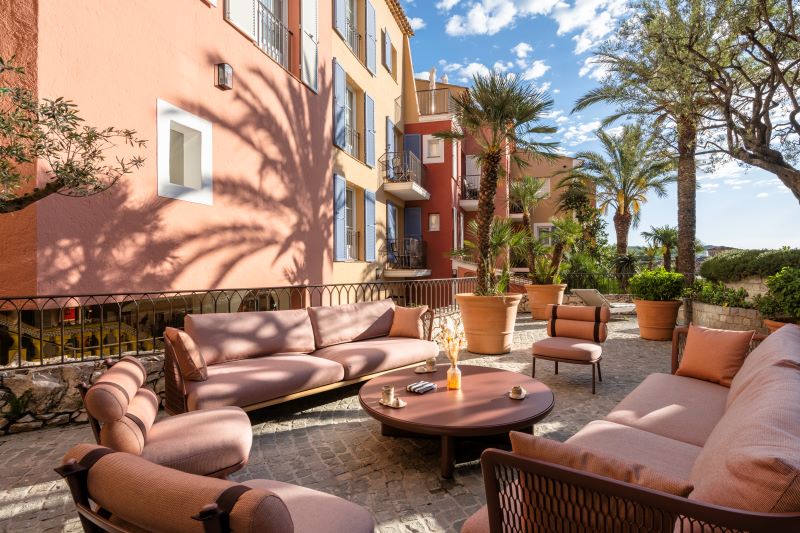 Lounge externo do Byblos com sofás e poltronas entre árvores