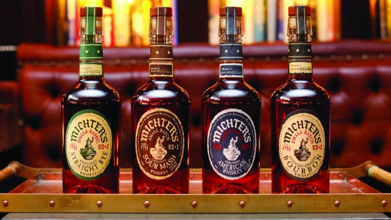 Quatro garrafas de uísque Michter's reunidas sobre uma base
