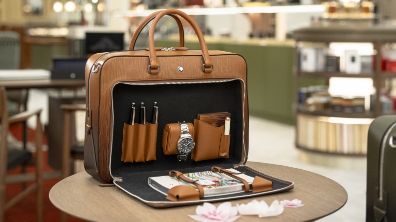 Writing Traveler aberta sobre mesa com relógio e acessórios em seu interior