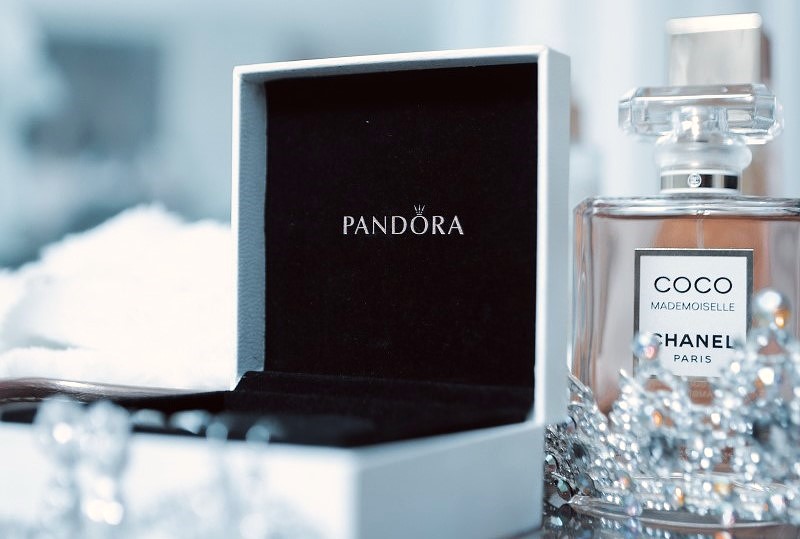 Peça da Pandora em caixa aberta ao lado do perfume Chanel Mademoiselle