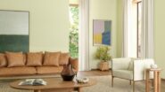 Sala com sofá marrom, poltrona, mesa de centro e paredes na cor Aipo
