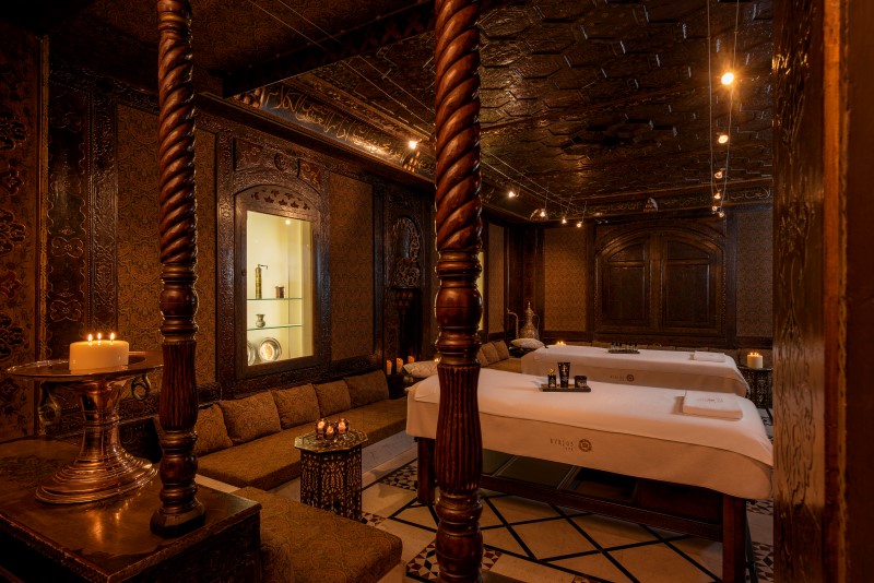 Sala ampla de tratamentos do Spa Byblos com duas camas e elementos em madeira