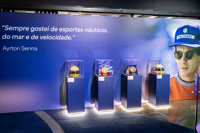 Showroom de Ayrton Senna com quatro capacetes e fotografia do piloto