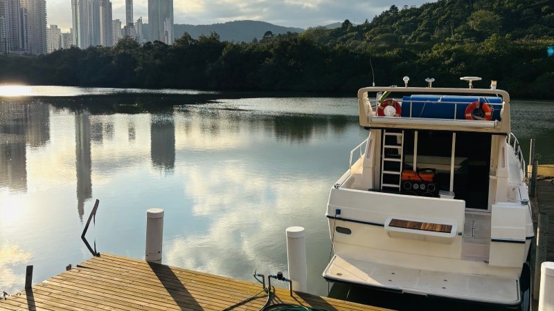 Lancha ancorada em um rio ao pôr do sol denota Riqueza e qualidade de vida