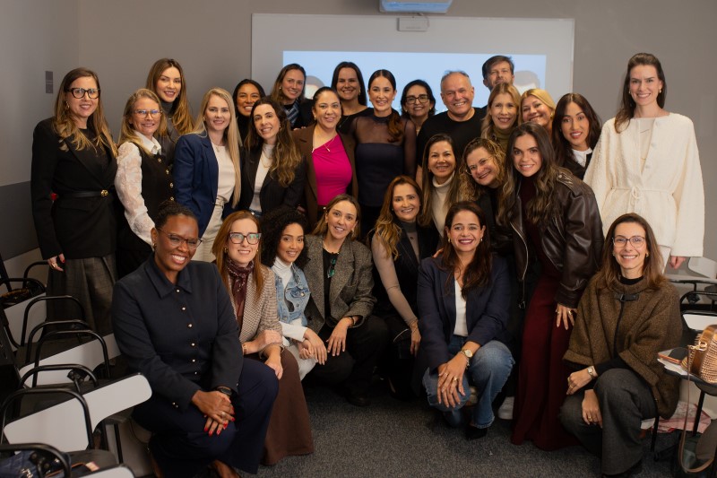 Alexandra Casoni posa ao lado de várias mulheres em encontro do grupo feminino.