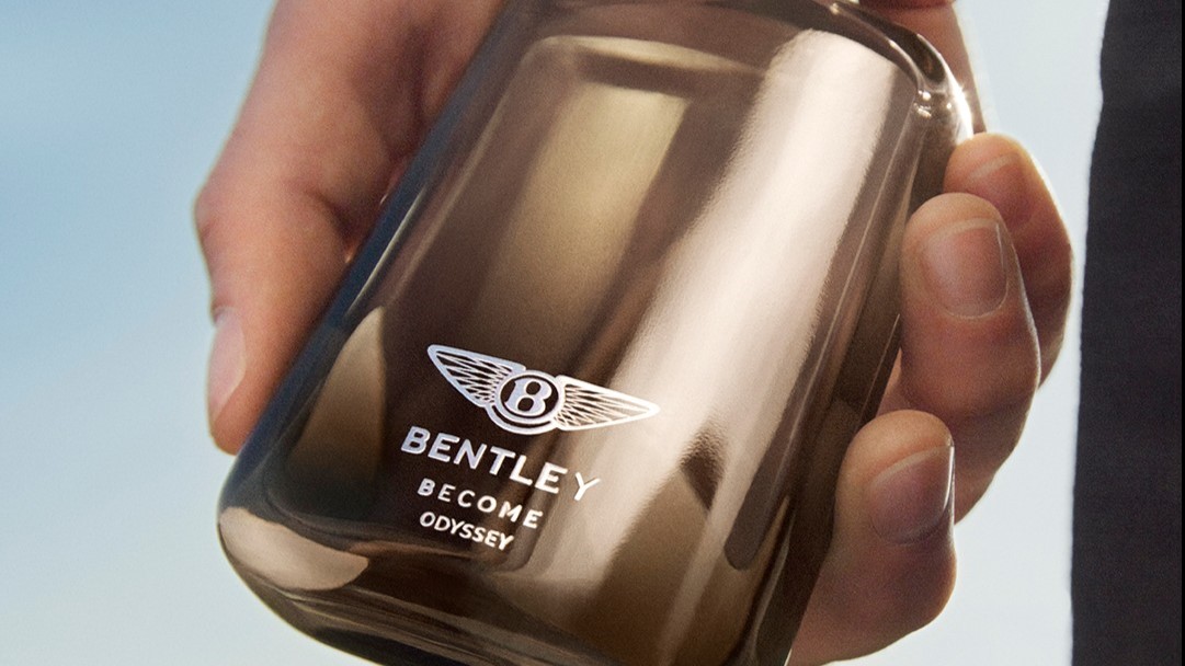 Frasco de Become Odyssey da Bentley Fragrances sendo segurado por uma mão
