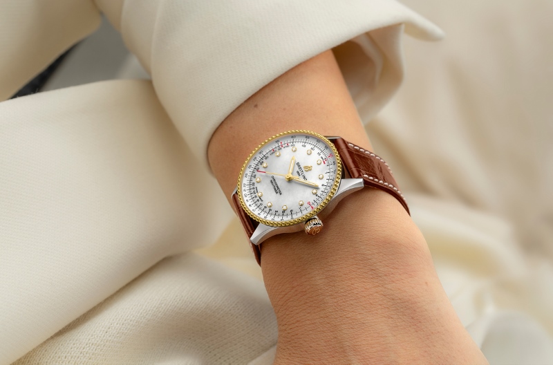 Navitimer 36 com detalhes em ouro amarelo e pulseira de couro marrom no pulso