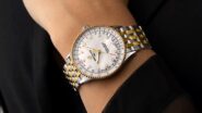 Relógio Breitling com detalhes em ouro amarelo e pulseira metálica no pulso