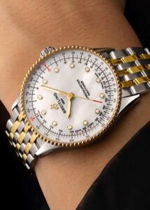 Relógio Breitling com detalhes em ouro amarelo e pulseira metálica no pulso