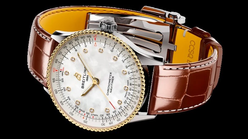 Navitimer 36 com pulseira metálica e detalhes em ouro amarelo no pulso