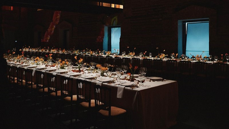 Mesa ampla com toalha branca, pratos e talheres preparada para o jantar na Pinacoteca
