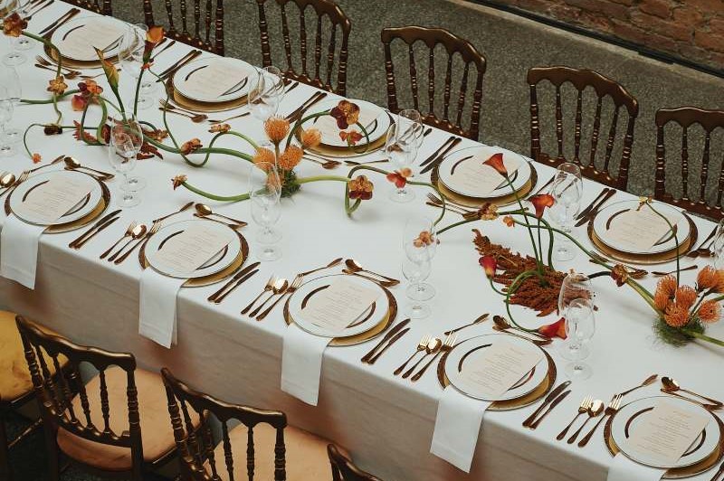 Vista superior de parte da mesa de jantar com pratos e talheres preparados para os convidados