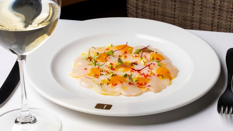 Carpaccio de vieira com redução de laranja e pistache