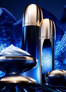 Produtos Guerlain Orchidée Impériale Concentrado da Longevidade em diferentes embalagens, sobre fundo azul