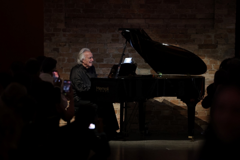 Maestro João Carlos Martins sentado ao piano durante o evento da Bvlgari