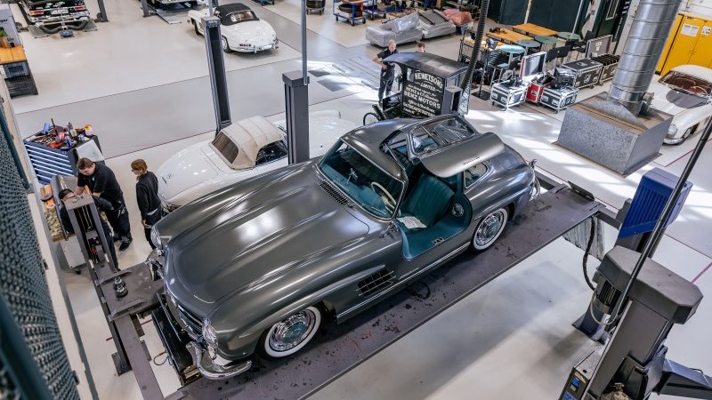 Automóvel clássico Mercedes-Benz com pintura especial sobre um elevador na área de restauração