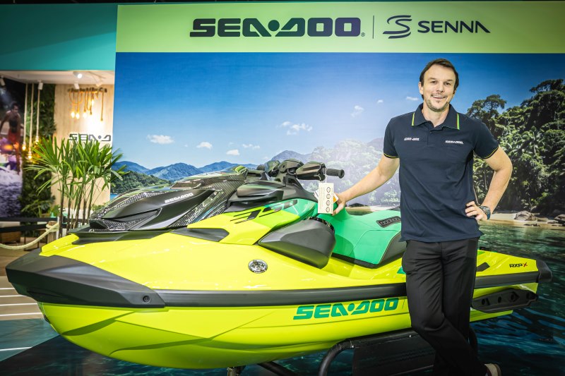 Michael Codd ao lado da Sea-Doo RXP-X Senna 350 com painel da marca ao fundo
