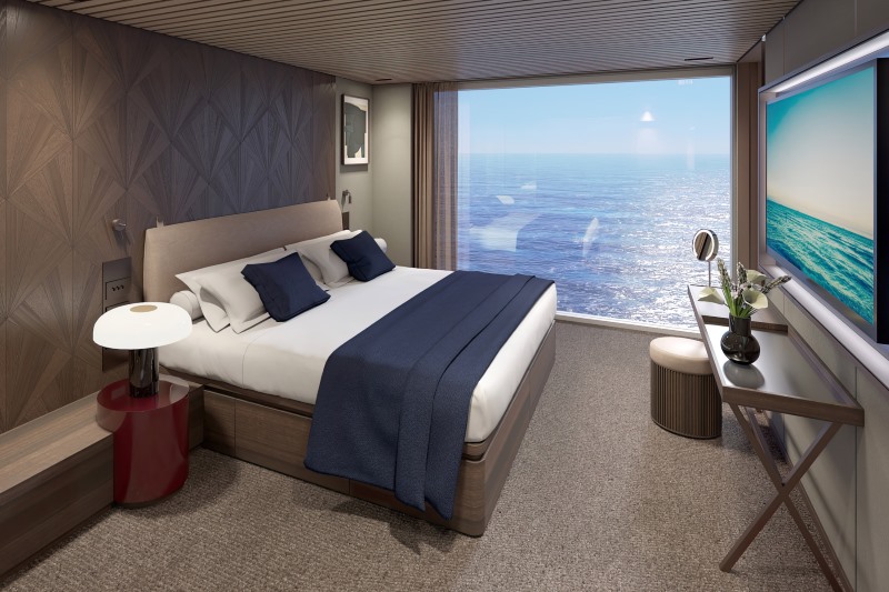 Acomodação duplex com cama à esquerda, janela com vista para o mar e televisão em frente à cama
